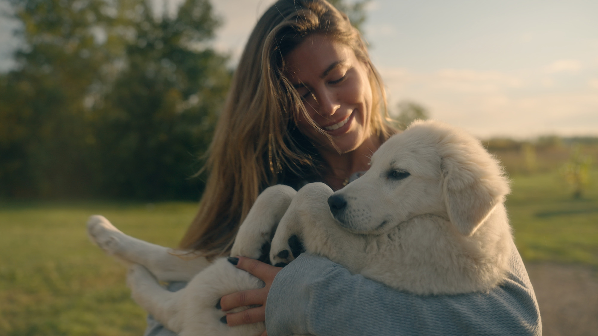 Must Love Dog's Alex Blumberg carrying a dog in her arms.
